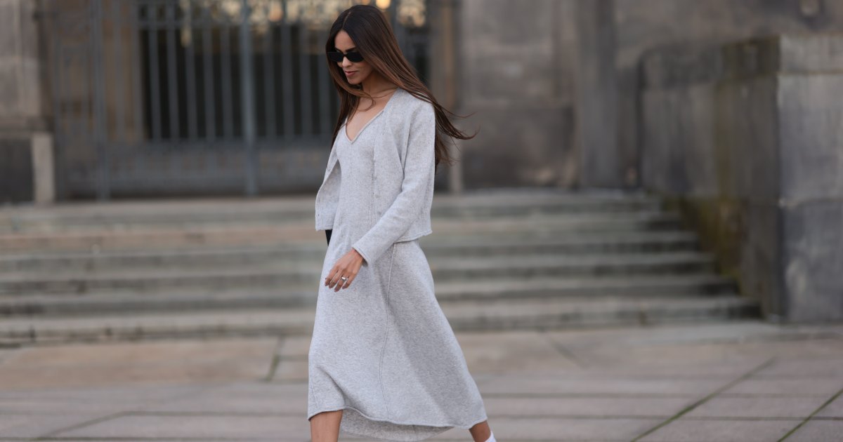 Jill Asemota seen wearing black vintage sunglasses, Dorothee Schumacher grey wool knit long dress, matching Dorothee Schumacher grey wool knit cardigan jacket, white cotton socks, Adidas white leather Samba sneakers, on November 04, 2023 in Berlin, Germany.