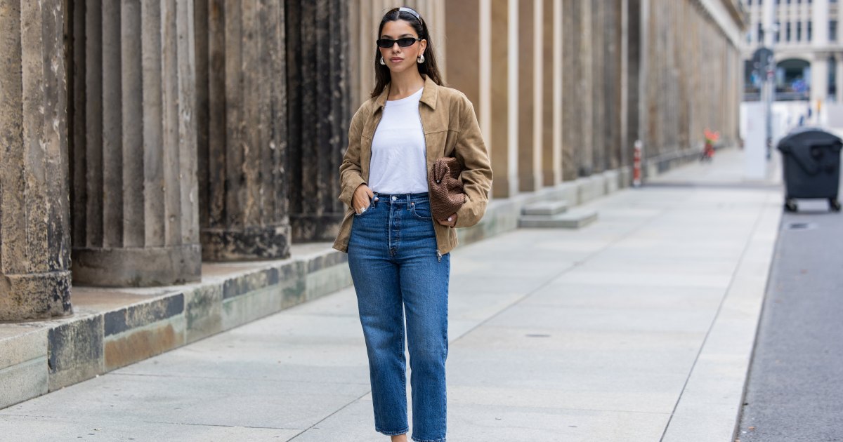 Bella Emar wears Levi’s blue denim jeans, white Cos t-shirt, brown Massimo Dutti Jacket, black H&M Heels, Mango sunglasses during the Berlin Fashion Week SS25 on July 01, 2024 in Berlin, Germany.
